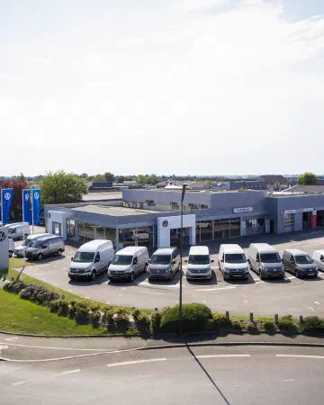 Photo aérienne de la concession Mouton Volkswagen Vitré avec des Véhicules Volkswagen utilitaires garés devant