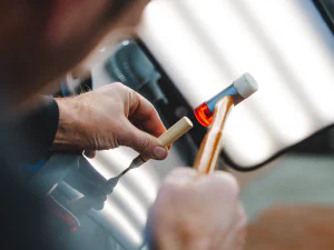 Debosselage d'une carrosserie avec un marteau et un poinçon
