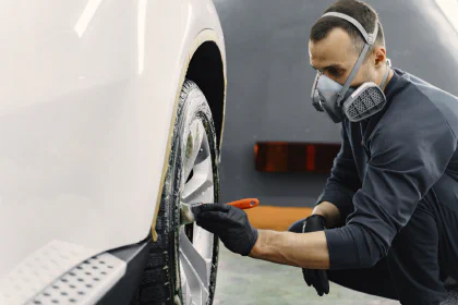 Photo d'un équipier des Concessions Mouton en train de rénover une jante de voiture